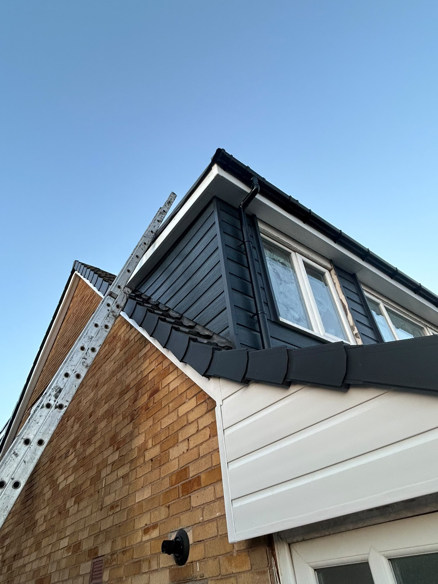 Grey tiled extension roof with access ladder and scaffolding