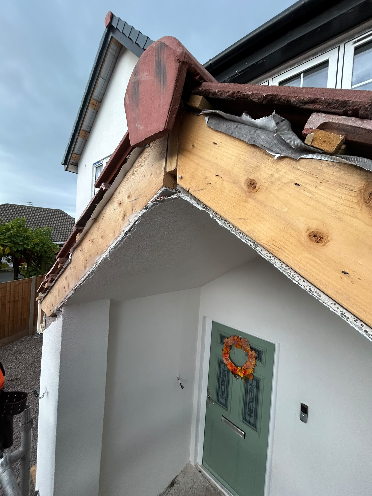 New porch roof structure and tiles above a front door