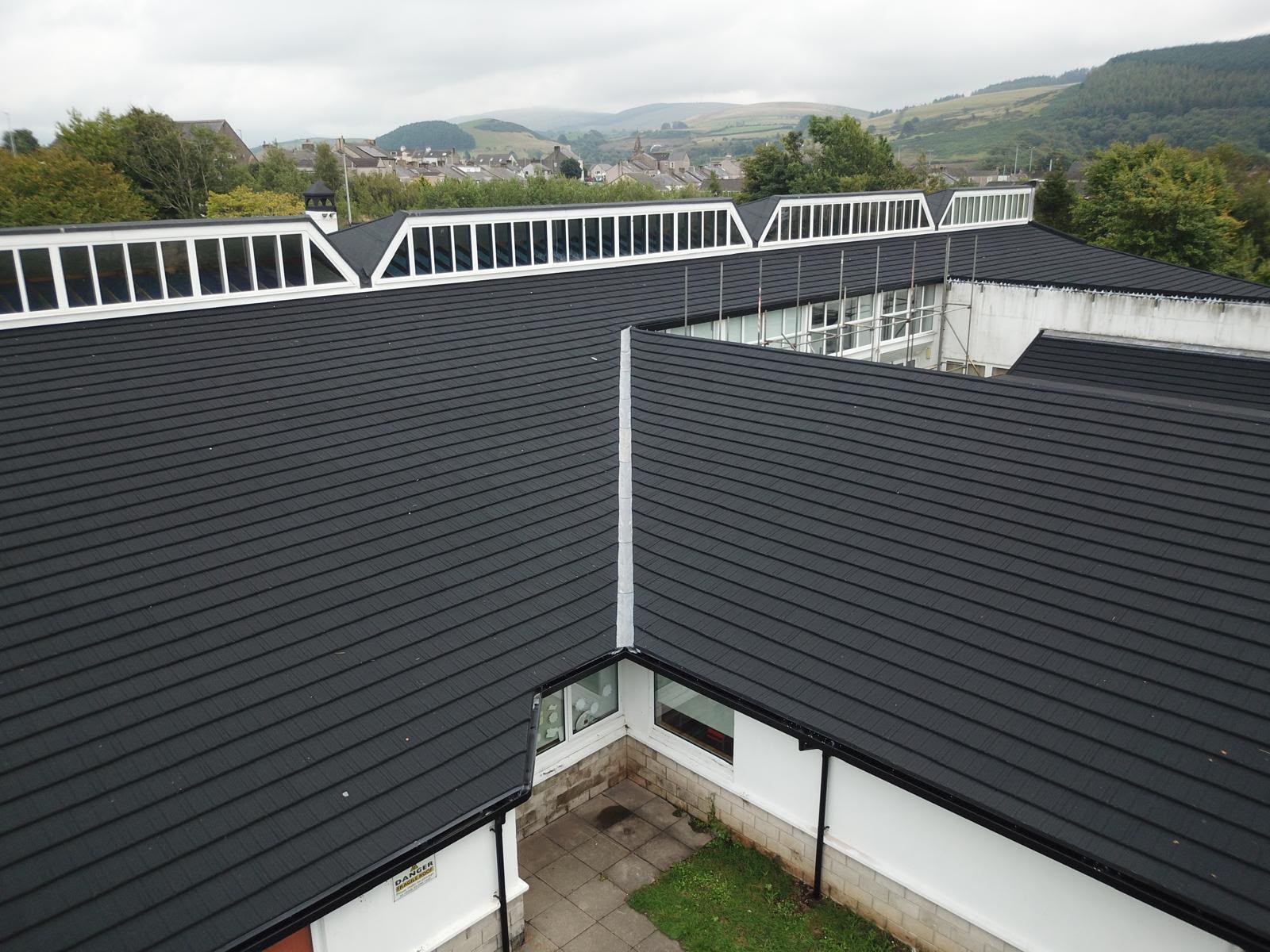 Dark tiled roof with clerestory skylights on a white building